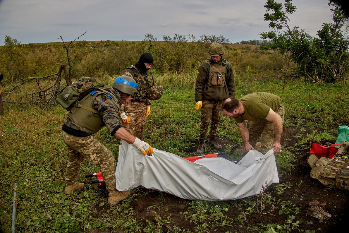 Ukraiņu karavīri savāc savu kritušo biedru