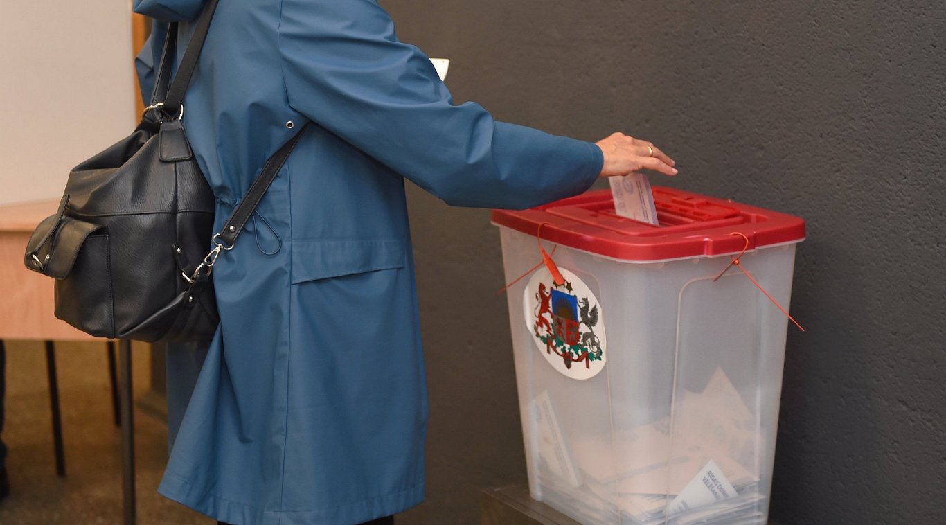 Vēlētāja nodod savu balsi vēlēšanu iecirknī