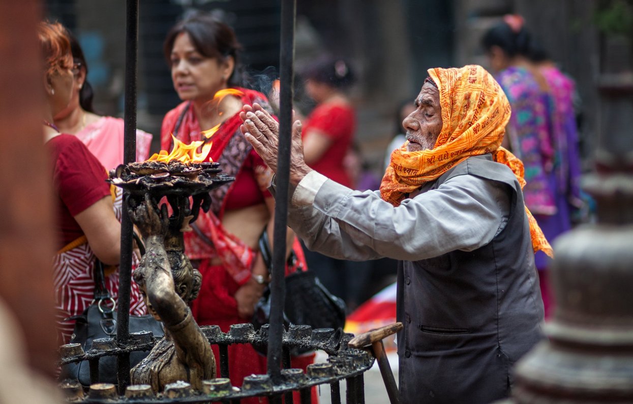 Vīrietis pielūgsmes jeb pūdžas laikā pie hinduistu tempļa Nepālas galvaspilsētā Katmandu. Attēls ilu...