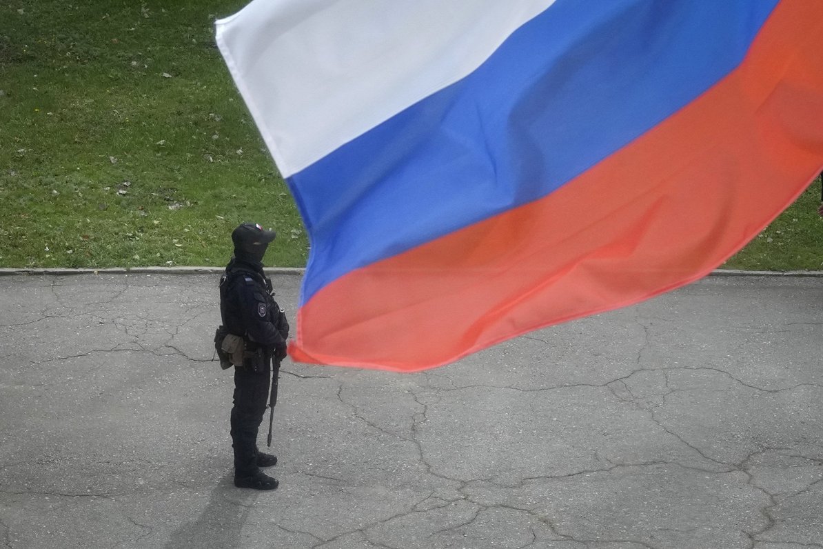 Krievijas speciālo uzdevumu vienības policists stāv zem Krievijas karoga okupētajā Luhanskā