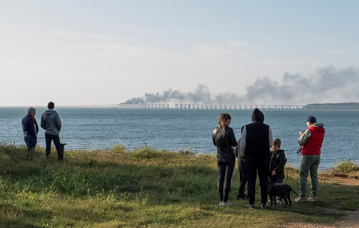 Cilvēki vēro tiltu, kas savieno Krimas pussalu ar Krieviju pēc sprādziena