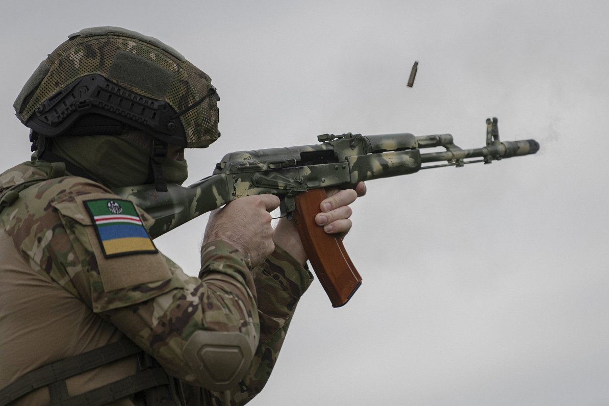 Čečenu brīvprātīgais karavīrs ar Ičkērijas un Ukrainas karogiem uz pleca