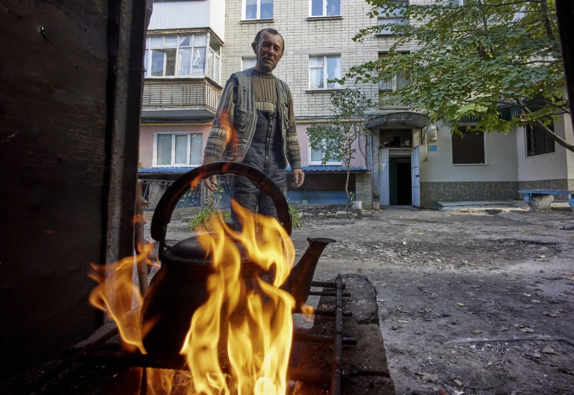 Nesen atbrīvotajā Ukrainas pilsētā Kupjanskā iedzīvotāji gatavo maltīti uz āra plītiņas. Pilsētā nav...
