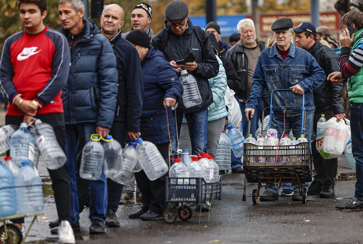 Ukrainas pilsētā Mikolajivā cilvēki stāv rindā pēc dzeramā ūdens. Krievijas raķešu triecienu dēļ dau...