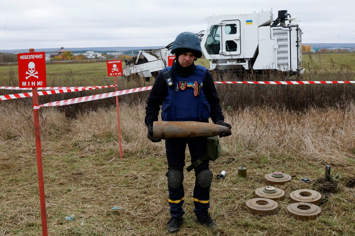 Ukrainas armijas karavīrs demonstrē Harkivas apgabalā atrastās mīnas