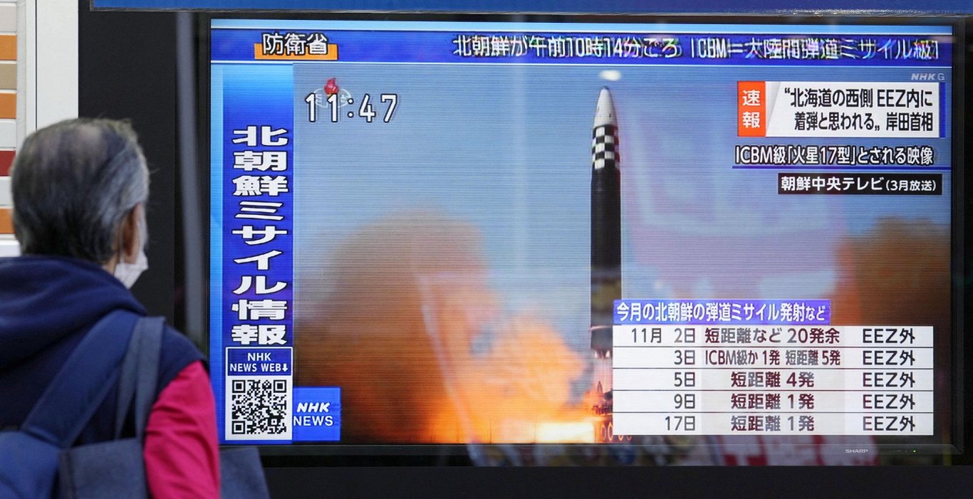 Japānā, Tokijā, garāmgājējs skatās televīziju, kur rāda starpkontinentālās ballistiskās raķetes izša...