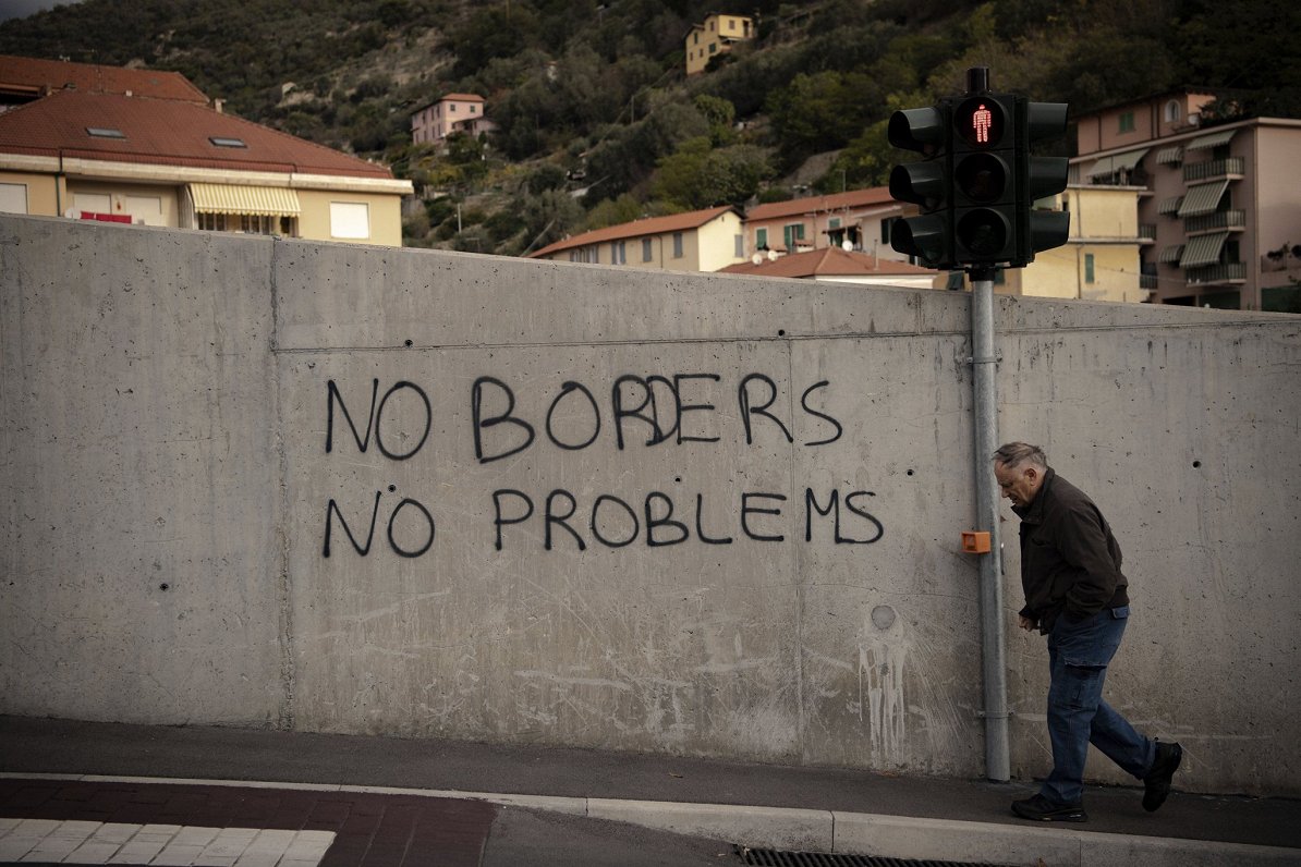 Grafiti uz sienas pie Itālijas un Francijas robežas. Uzraksts vēsta &quot;Nav robežu, nav problēmu&q...