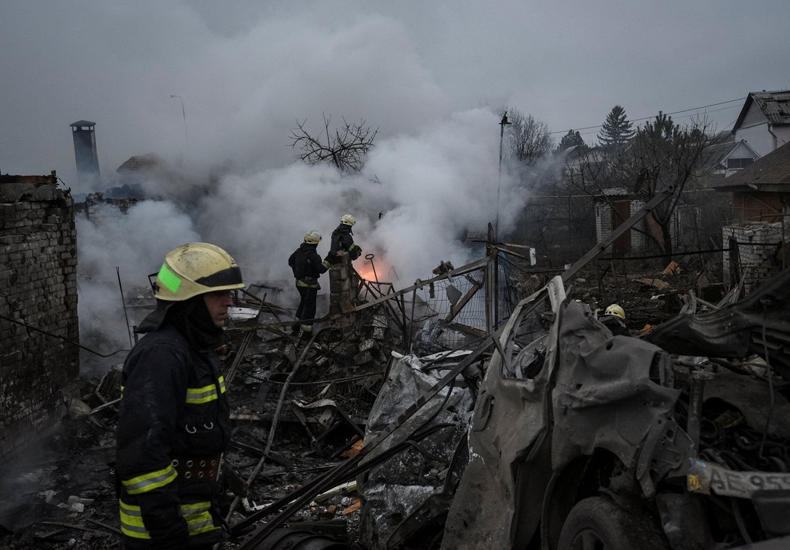 Ugunsdzēsēji dzēš Krievijas raķešu uzbrukumā Dņipro pilsētā Ukrainā sagrautās ēkas 26.11.22.