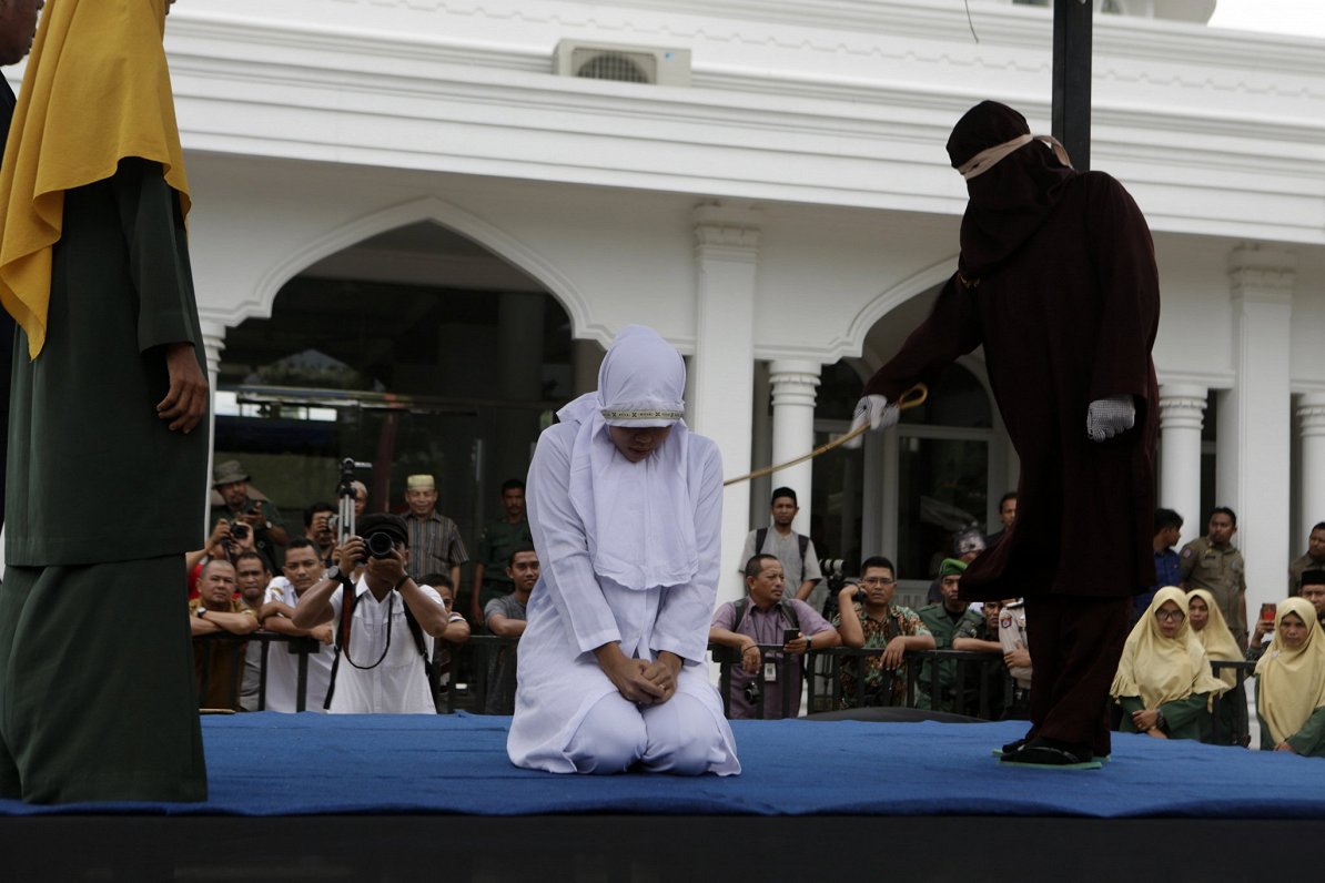 Ačehas provincē Indonēzijā sieviete saņem pērienu, jo viņai bijušas seksuālas attiecības ārpus laulī...