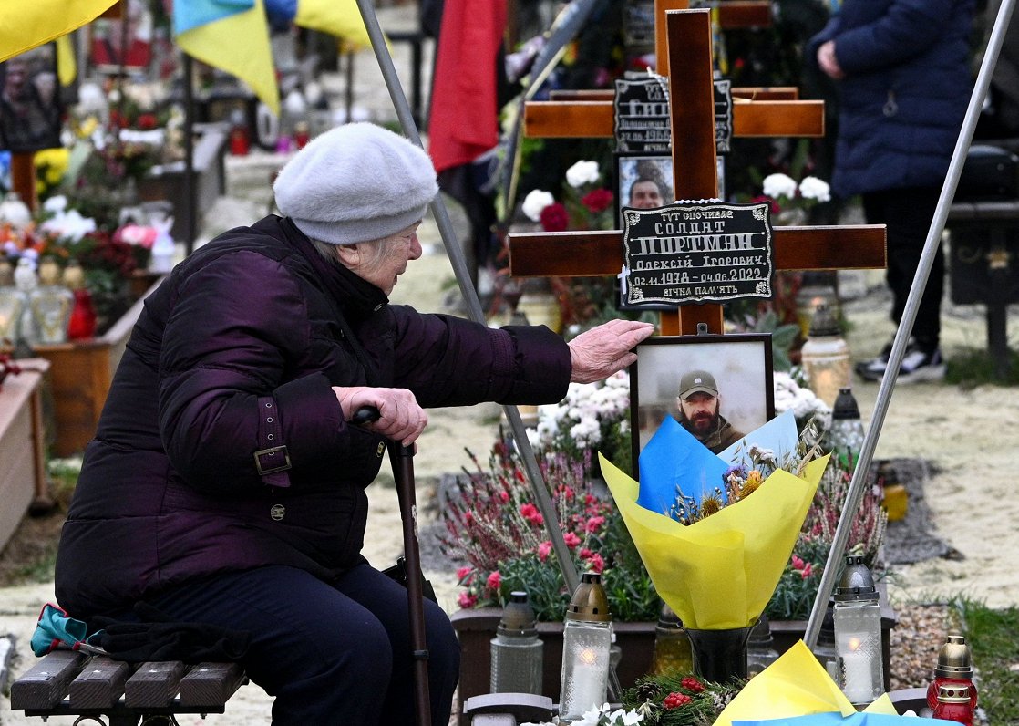Ukraiņu sieviete pie kritušā karavīra kapa Ļvivas pilsētā