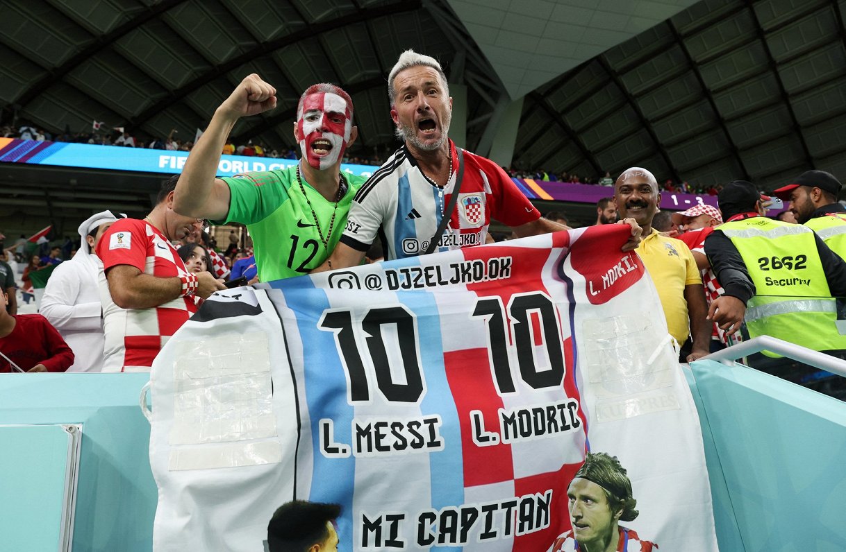 Futbola fani ar plakātu, uz kura ir Lionela Mesi un Lukas Modriča vārdi
