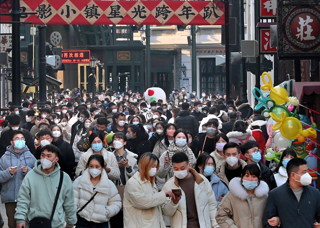 Tūristi pastaigājas Ķīnas lielpilsētas Džendžou ielās