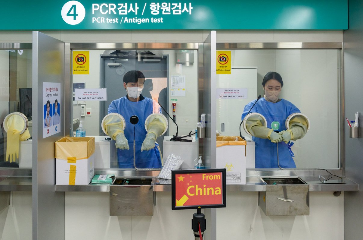 Inčhonas lidostā Dienvidkorejā darbinieki gatavojas testēt pasažierus, kas atlidojuši no Ķīnas