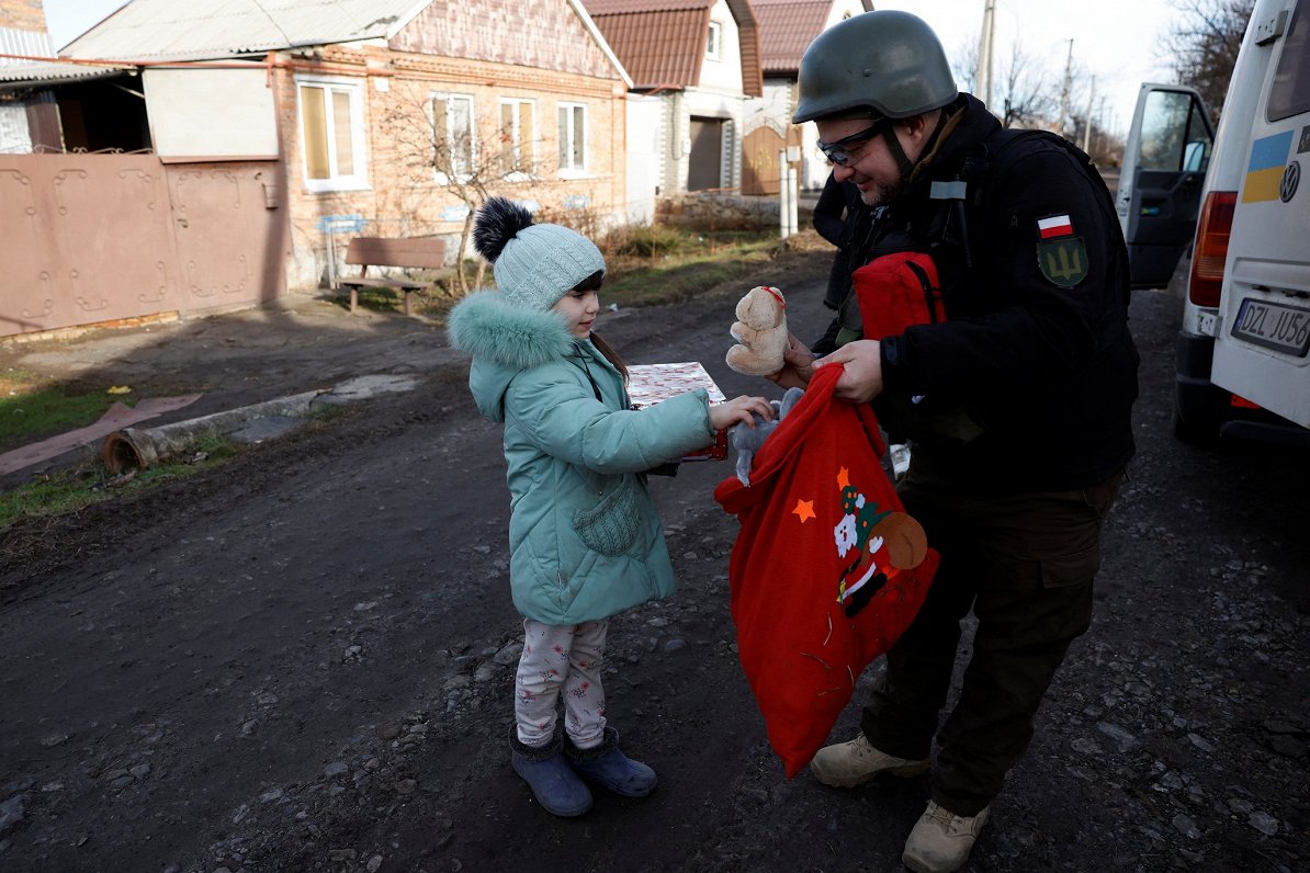 6-летняя жительница Бахмута Ангелина получает рождественский подарок от представителя польского благ...