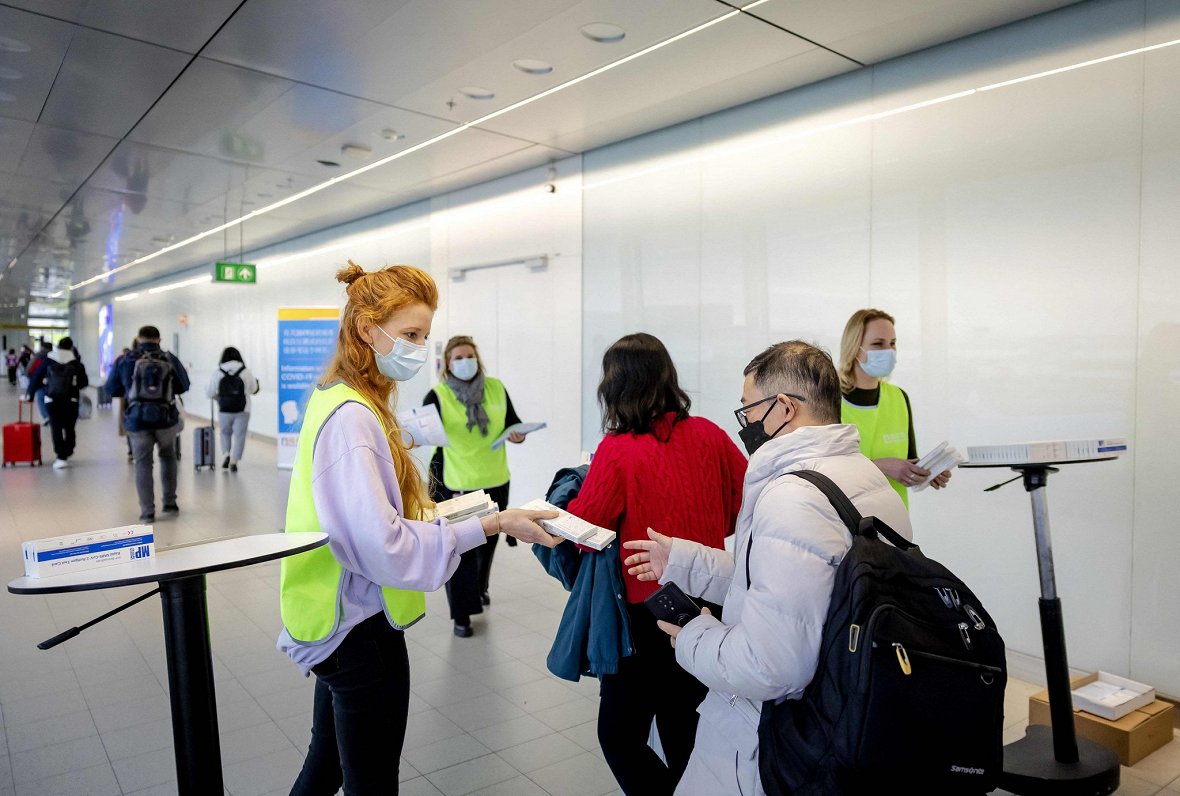 Shipholas lidostā Amsterdamā ieceļotājiem no Ķīnas tiek izsniegti bezmaksas Covid-19 paštesti