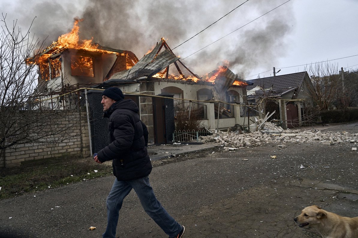 Vīrietis pie degošas mājas Ukrainas pilsētā Hersonā, 6. janvārī, kad Krievija it kā bija izsludināju...
