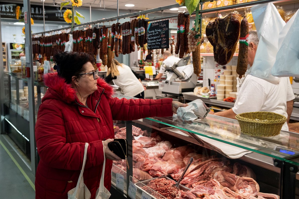 Sieviete pērk pārtiku tirgū Budapeštā, Ungārijā, 2022. gada 3. decembris