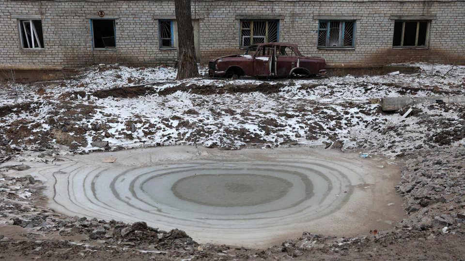 Затянутая льдом воронка от удара снаряда в Северске Донецкой области. 13.01.2023