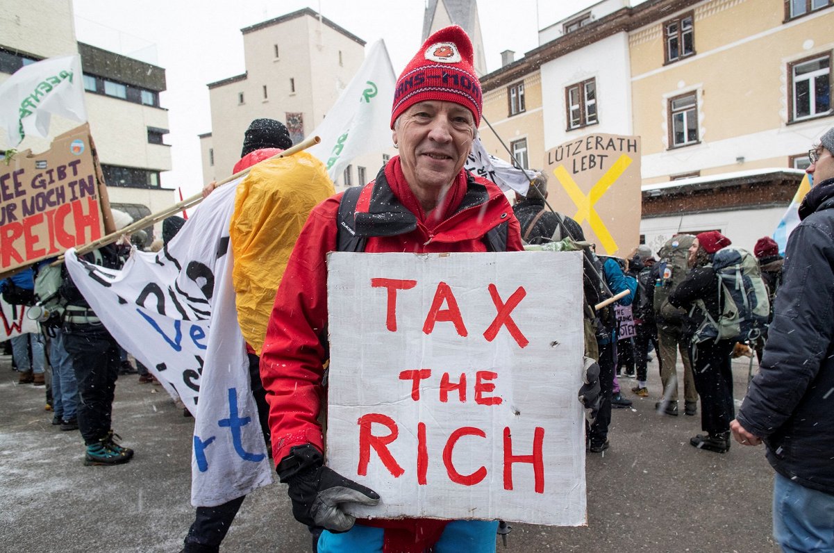 Protesta akcijas dalībnieks Davosā ar aicinājumu aplikt bagātniekus ar augstākiem nodokļiem