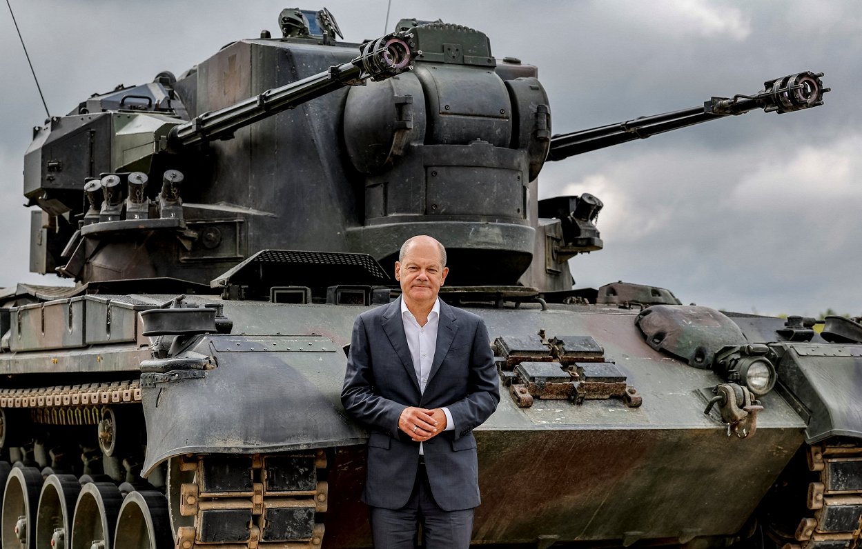 Vācijas kanclers Olafs Šolcs pozē pie tanka, 2022. gada augustā apmeklējot Ukrainas karavīru apmācīb...