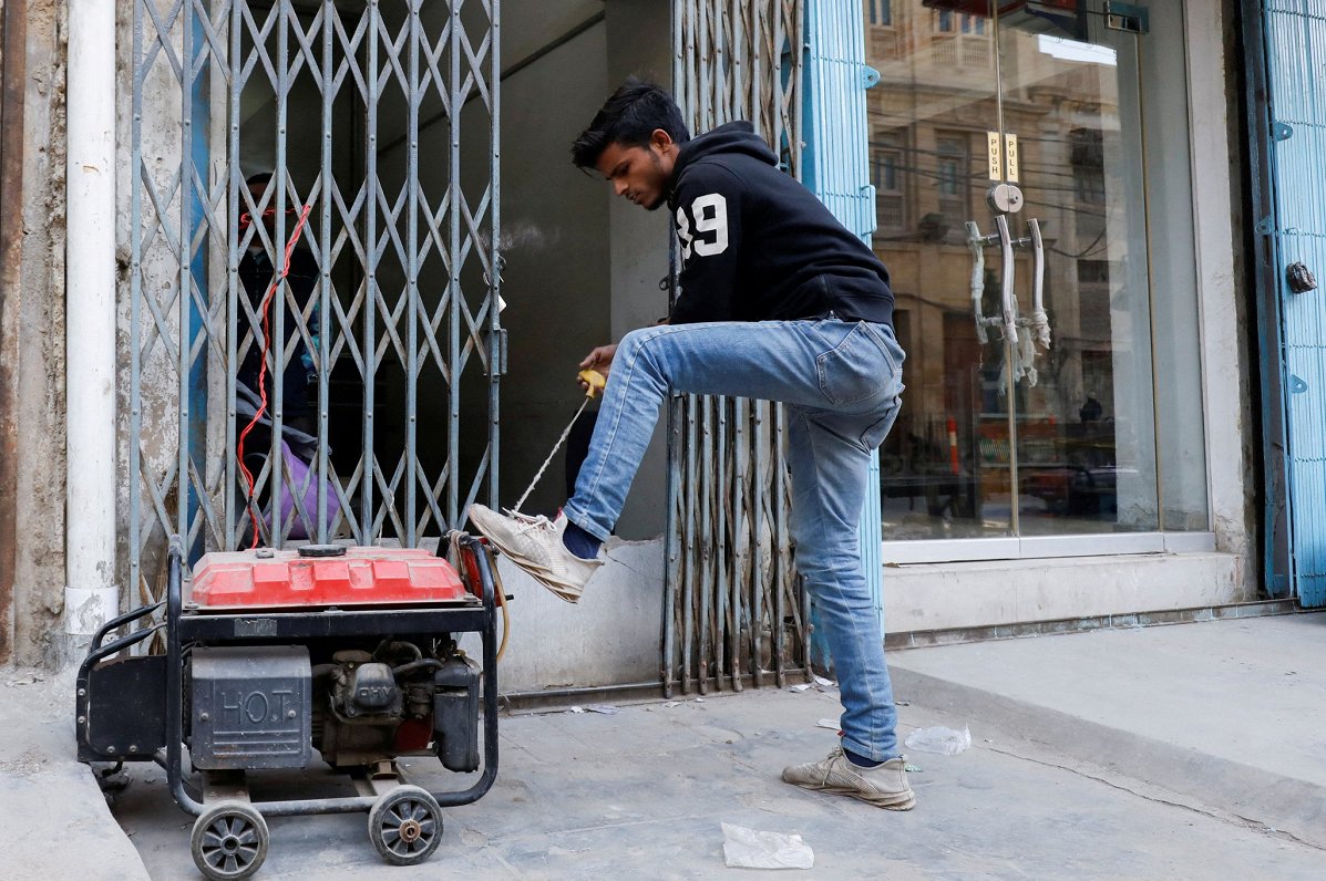 Pakistānas pilsētā Karāči vīrietis mēģina iedarbināt elektrības ģeneratoru