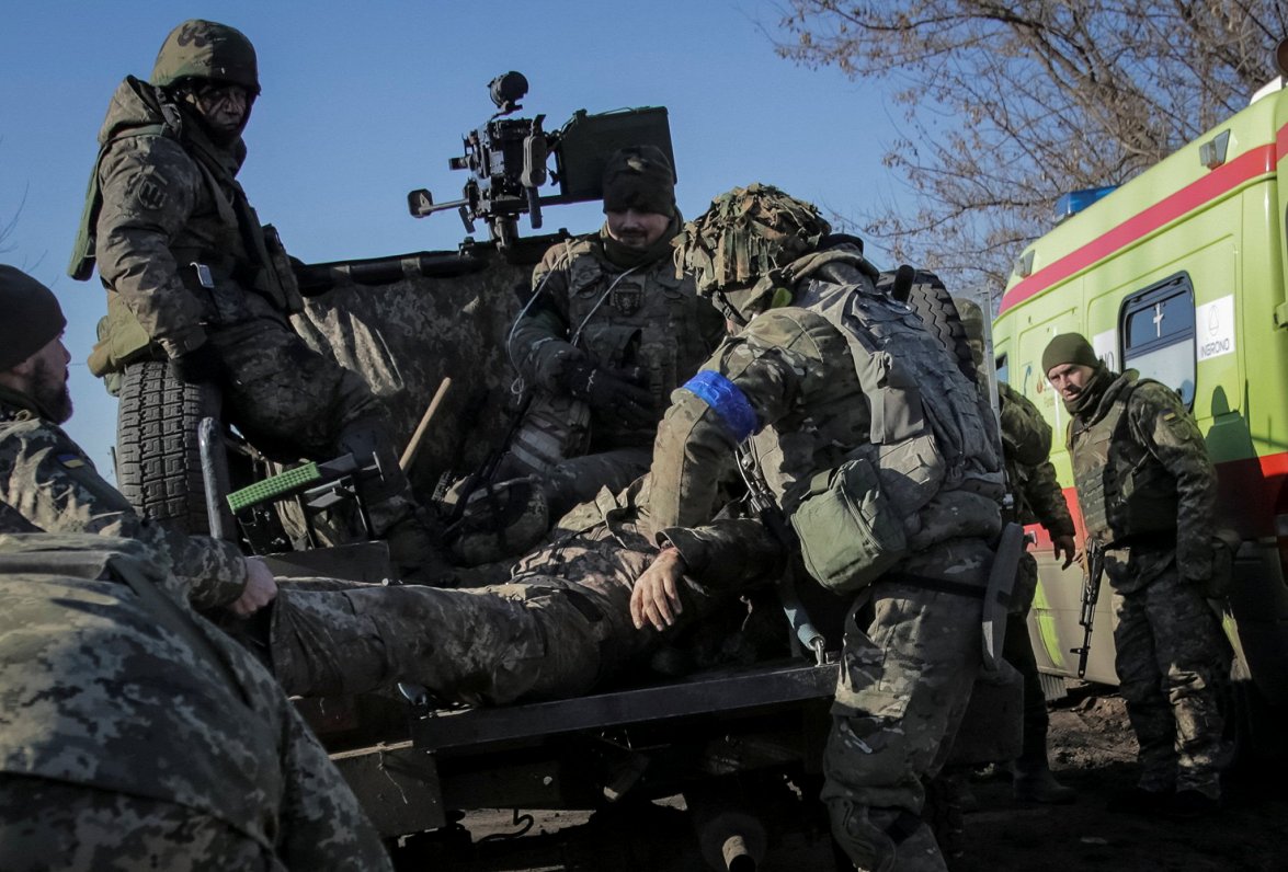 Ukrainas armijas karavīri evakuē savu Bahmutas kaujās ievainoto biedru