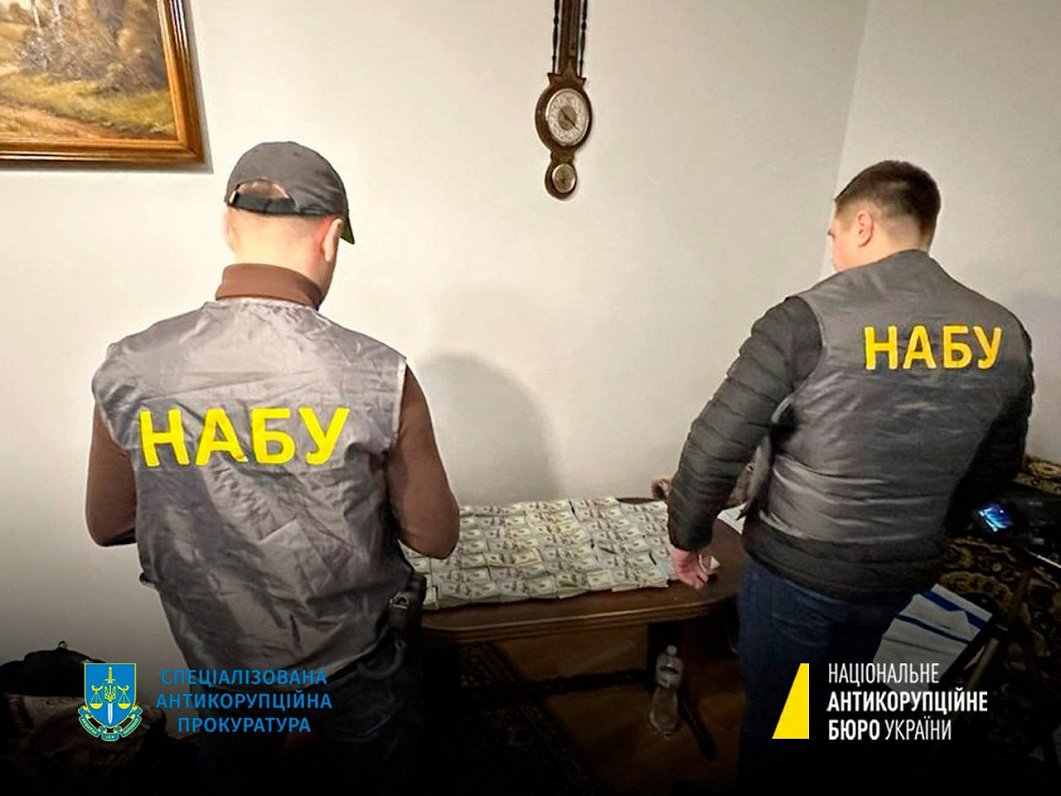 Ukrainas Korupcijas apkarošanas biroja darbinieki ar kratīšanā atrasto naudu