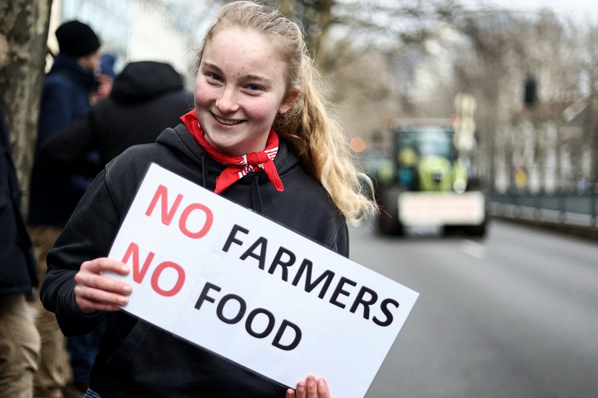 Protesta akcijas dalībniece ar lozungu &quot;Nav zemnieku, nav pārtikas&quot;