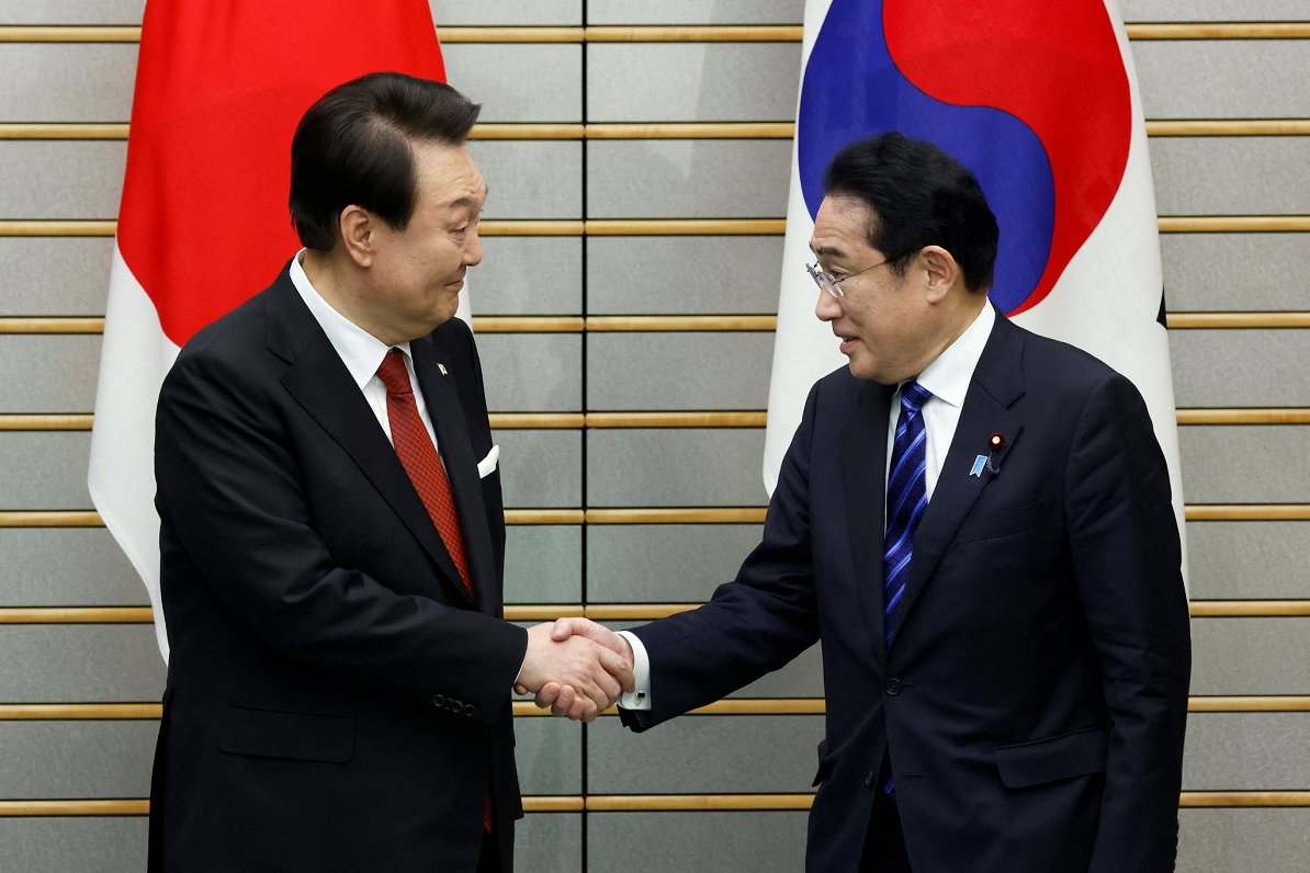 Japānas premjers Fumio Kisida (no labās) tiekas ar Dienvidkorejas prezidentu Junu Sukjolu