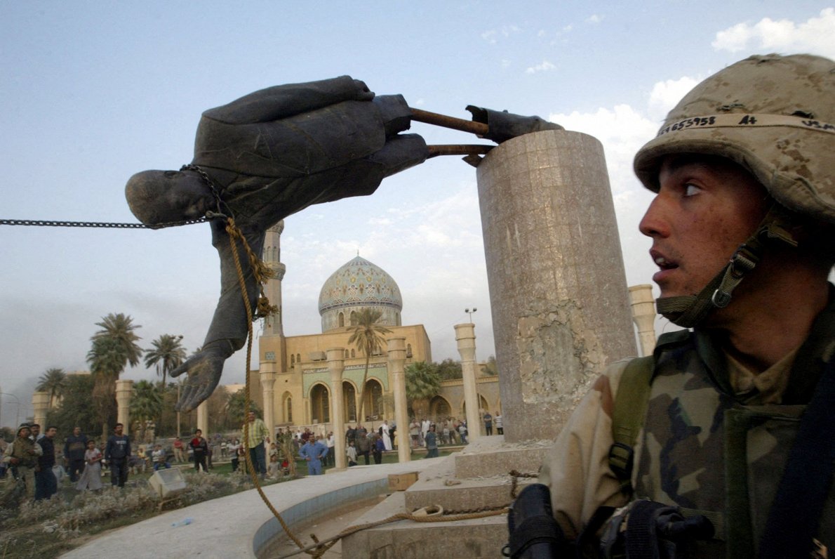 2003. gada aprīlī ASV karavīrs Bagdādē vēro, kā tiek nogāzta Irākas vadoņa Sadama Huseina statuja