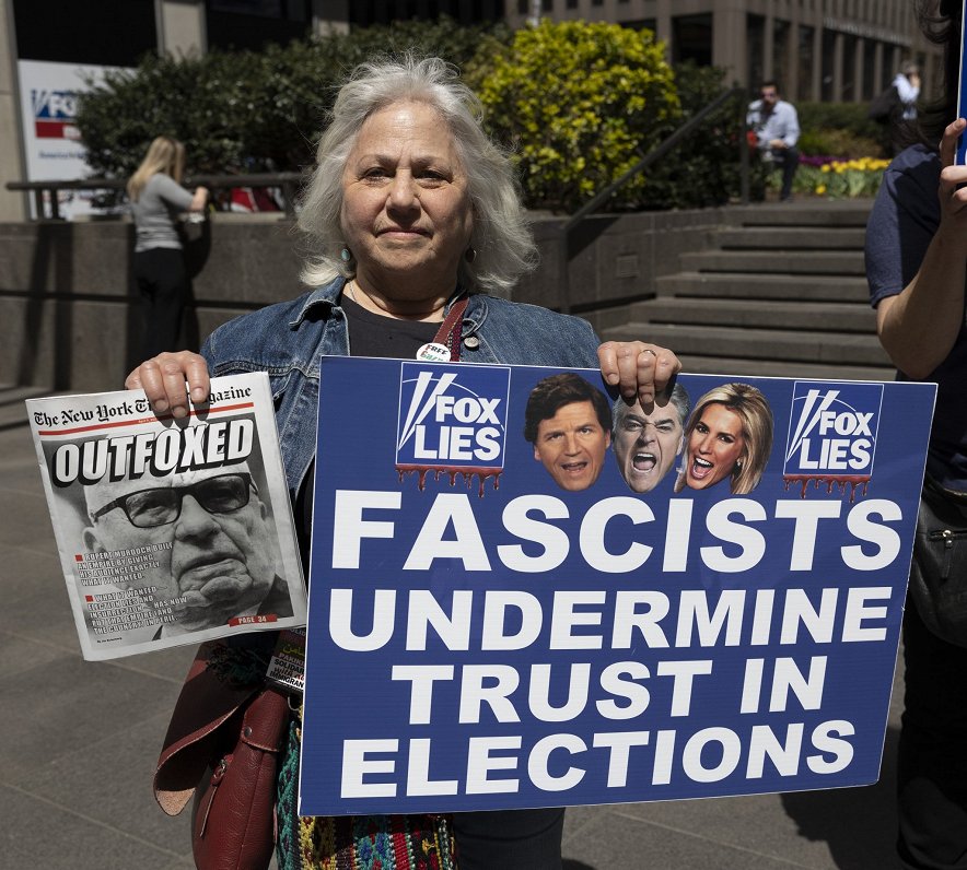 Ņujorkā sieviete protestē pret telekanālu &quot;Fox News&quot; ar plakātu &quot;Fox melo. Fašisti vā...