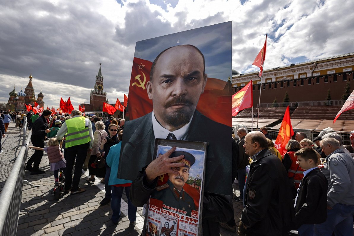 Boļševiku vadoņa Ļeņina atbalstītāji ar viņa portretu pulcējušies Sarkanajā laukumā Maskavā