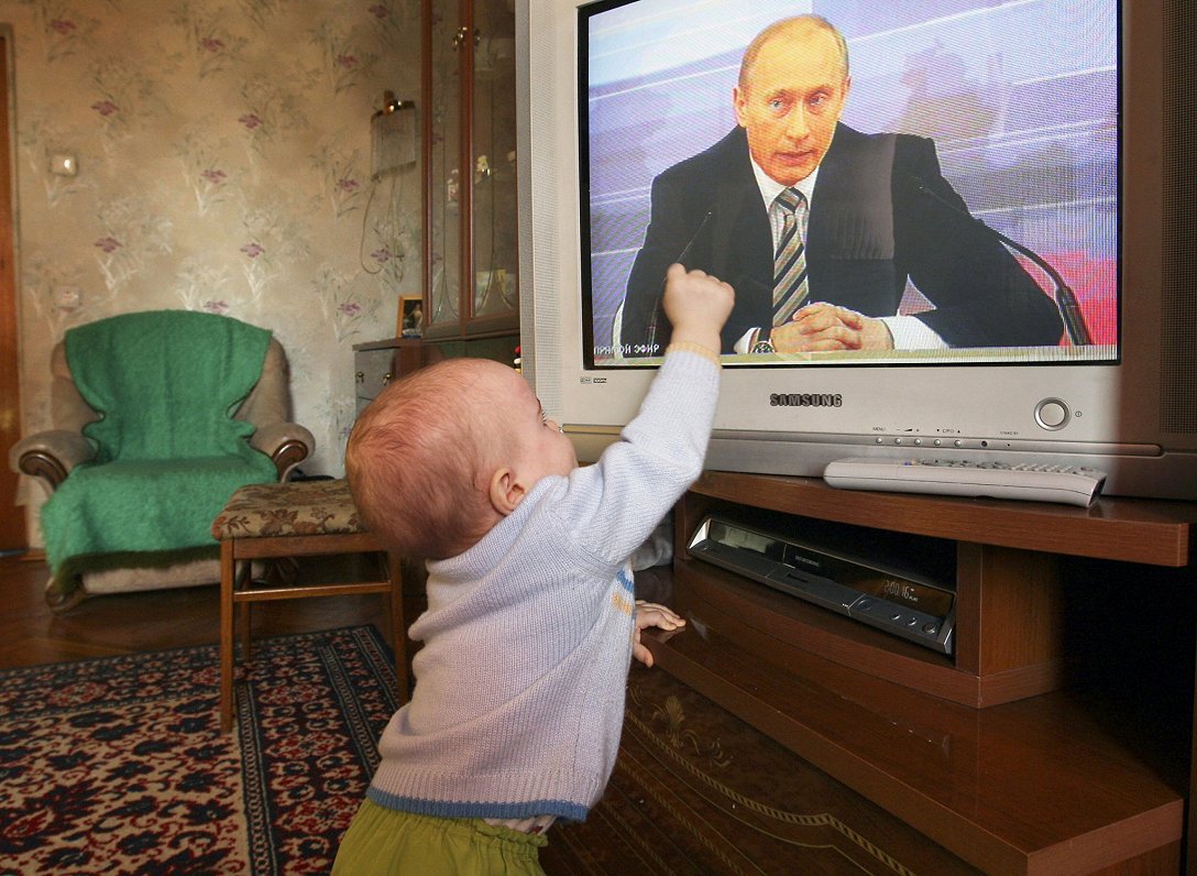 Mazulis pie televizora, kas pārraida Krievijas līdera Vladimira Putina runu