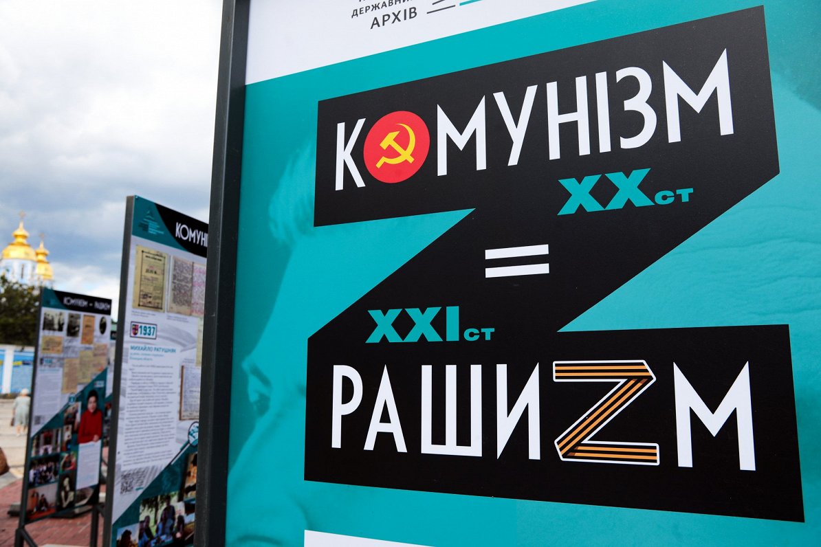 Kijivas ielās redzamais plakāts, kas liek vienlīdzības zīmi starp 20. gadsimta komunismu un 21. gads...
