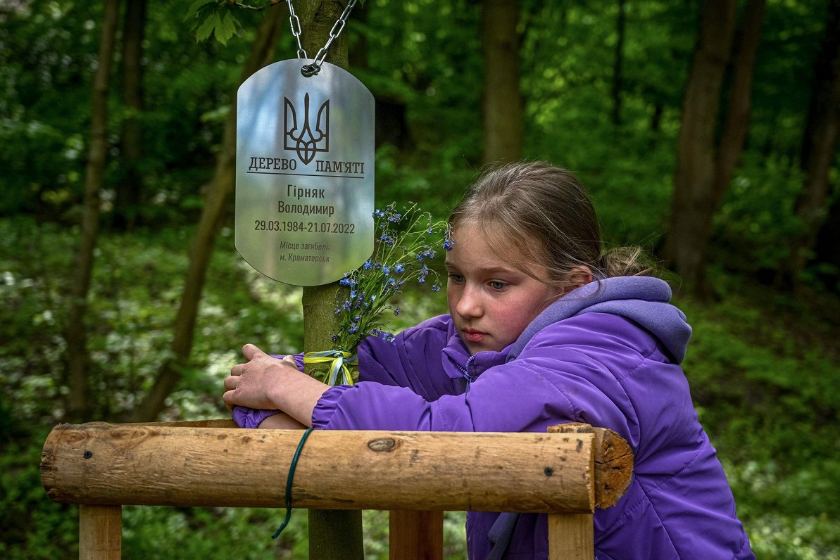 Девочка и мемориальное дерево в честь погибшего отца. Украина, Львов. 12.05.2023