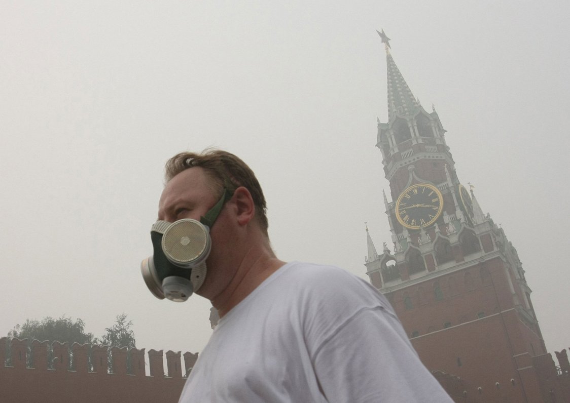 Maskavā vīrietis ar gāzmasku cenšas pasargāt sevi no smoga