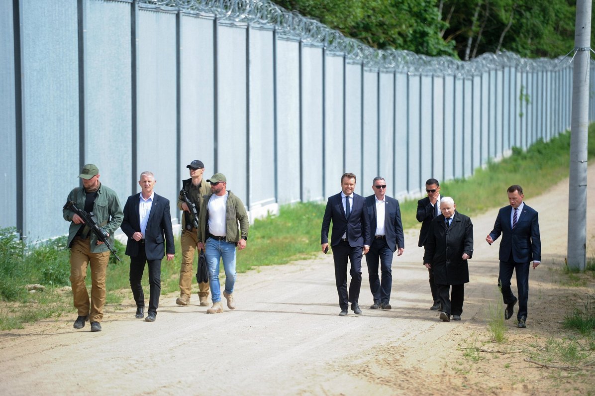 Polijas valdības delegācija pie žoga, kas uzbūvēts uz Polijas un Baltkrievijas robežas