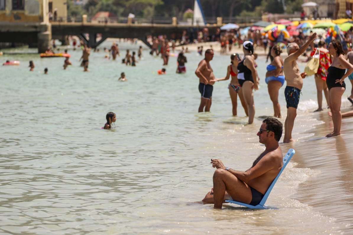 Cilvēki mēģina veldzēties Sicīlijas pilsētas Palermo pludmalē