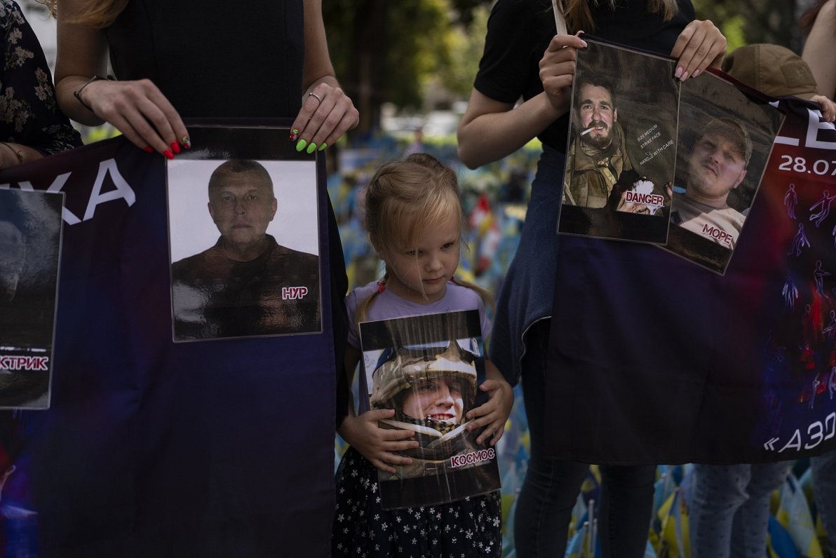 Девочка держит фотографию украинского солдата, погибшего в результате прошлогоднего теракта в Еленов...