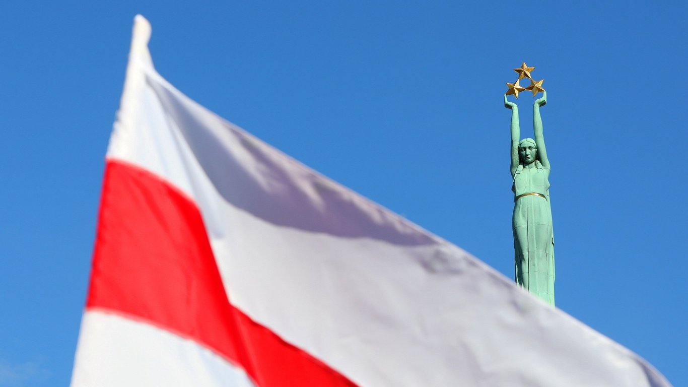 Исторический флаг Беларуси на фоне Памятника Свободы в Риге. Иллюстративное фото.
