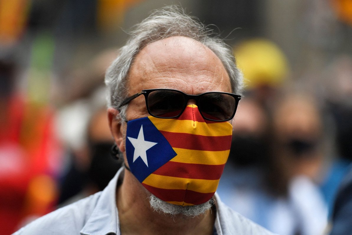 Vīrietis ar sejas masku Katalonijas karoga krāsās