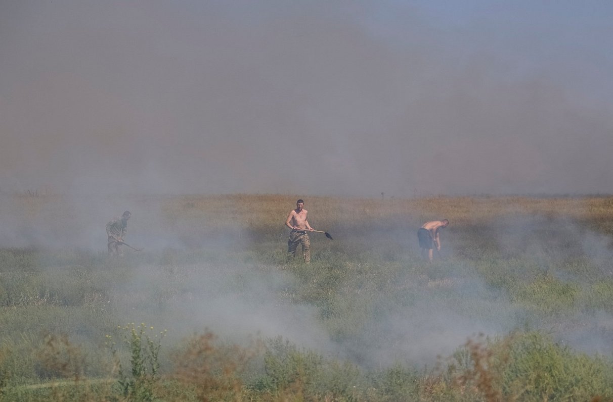 Бойцы ВСУ закапывают горящую у позиций траву. Запорожская область. 31.08.2023