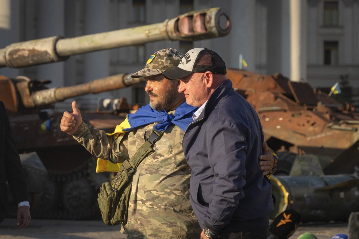 Ukrainas armijas karavīrs pozē fotogrāfijai pie iznīcinātas Krievijas armijas militārās tehnikas Kij...