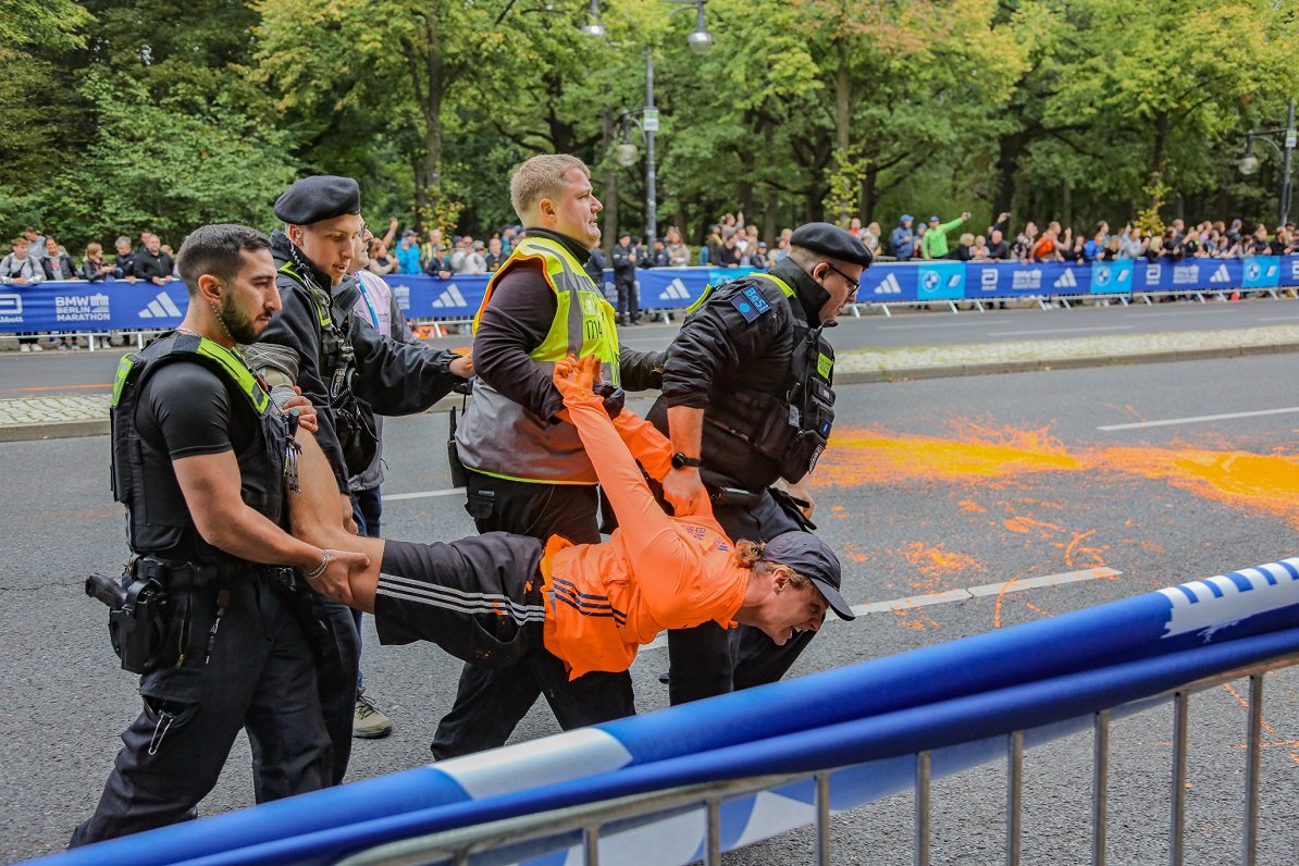 Kārtības sargi aiztur vides aktīvisti par cenšanos apturēt Berlīnes maratonu.