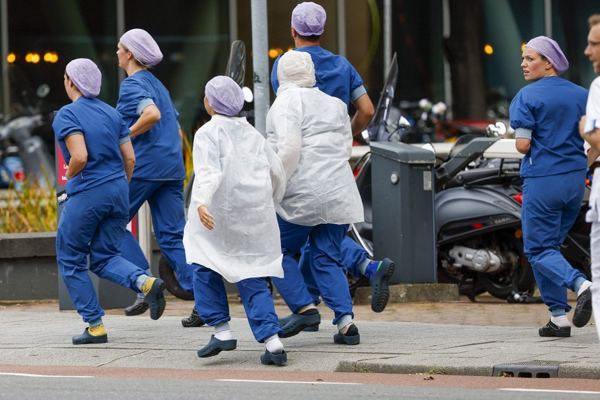 Ilustratīvs attēls: medicīnas personāls skriešus pamet Roterdamas Erasma Universitātes medicīnas cen...