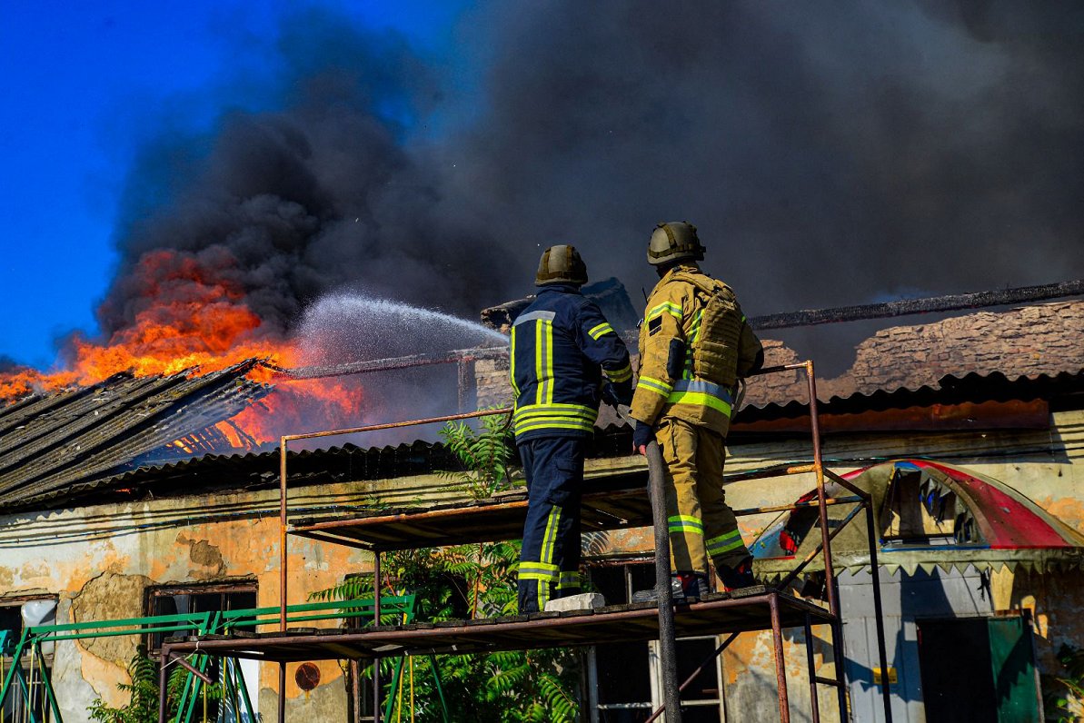 Ilustratīvs attēls: Ugunsdzēsēji cīnās ar liesmām kādā ēkā Ukrainas pilsētā Hersonā pēc Krievijas sp...