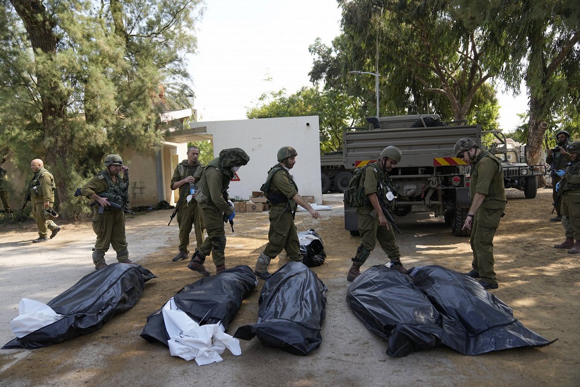 izraēliešu karavīri pārvieto &quot;Hamas&quot; kaujinieku nogalinātos cilvēkus Kfar Aza kibucā