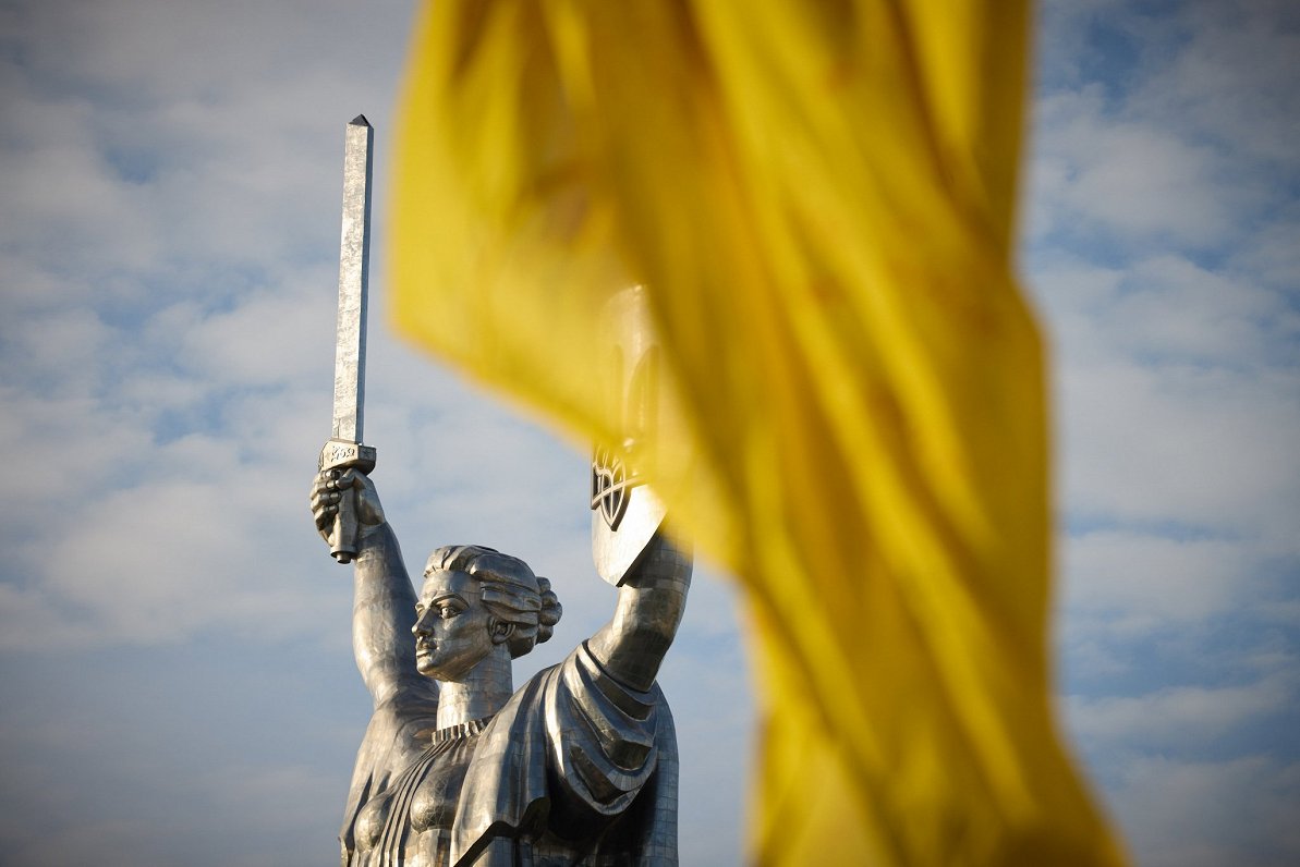 Kijivas statuja Ukrainas karoga fonā