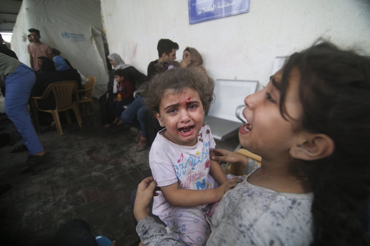 Izraēlas triecienos ievainotie palestīniešu bērni raud pie slimnīcas Rafas bēgļu nometnē, Gazas josl...