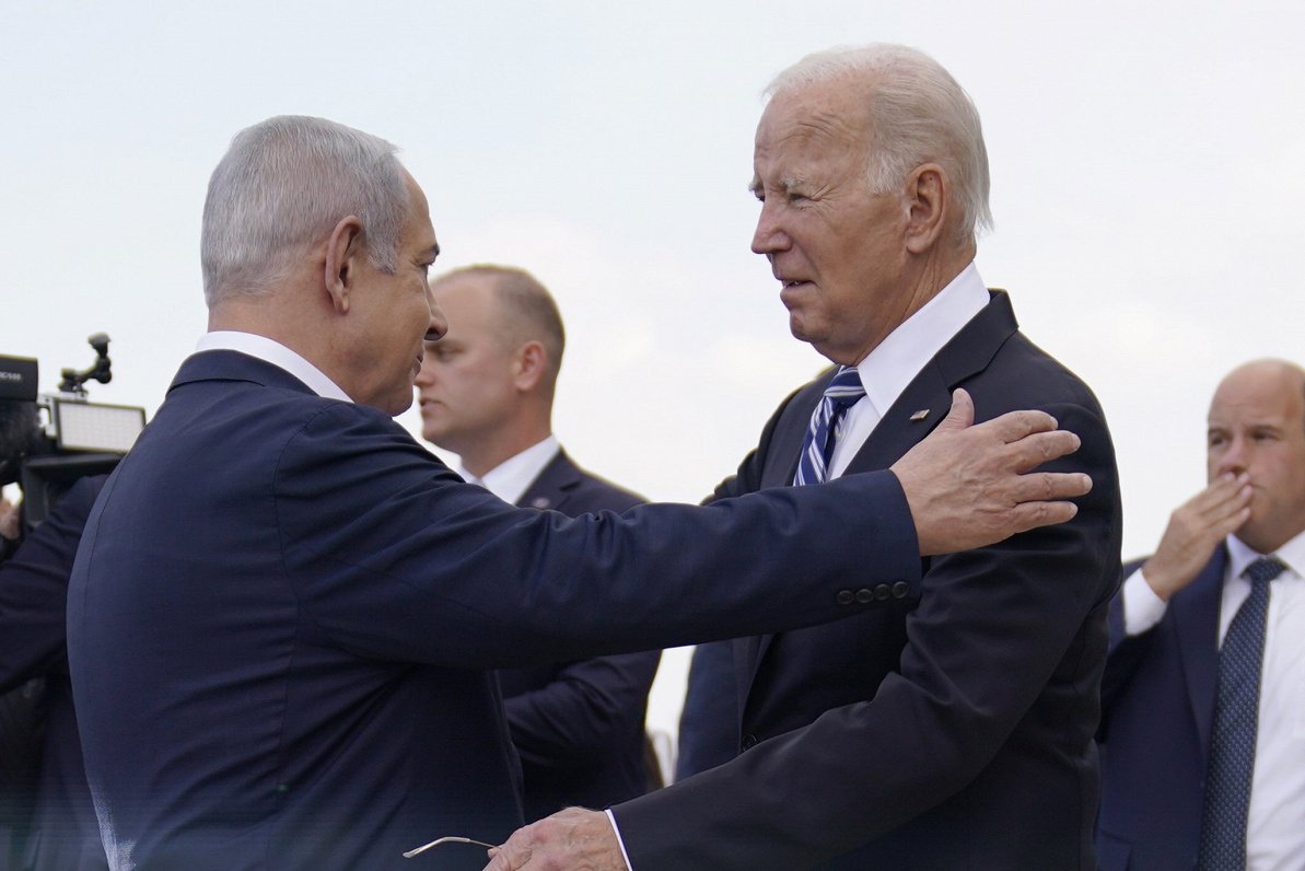 ASV prezidents Džo Baidens (no labās) pēc ierašanās Izraēlā sasveicinās ar šīs valsts premjeru Benja...